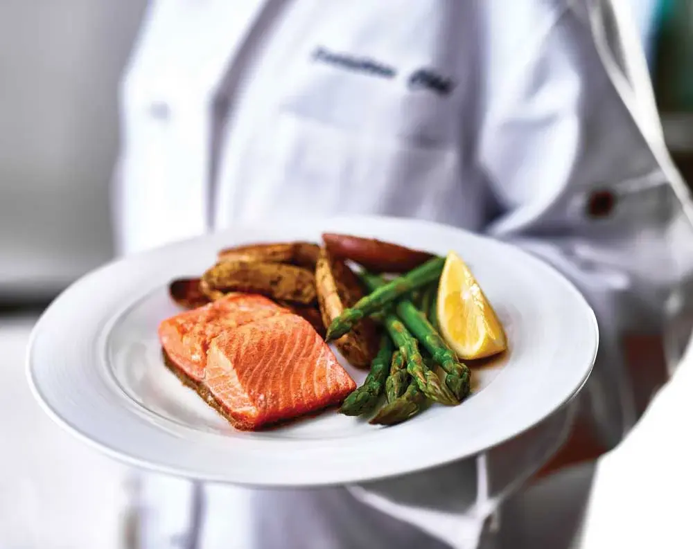 The Savoy Chef Created Meals, chef delivering a finished dish.