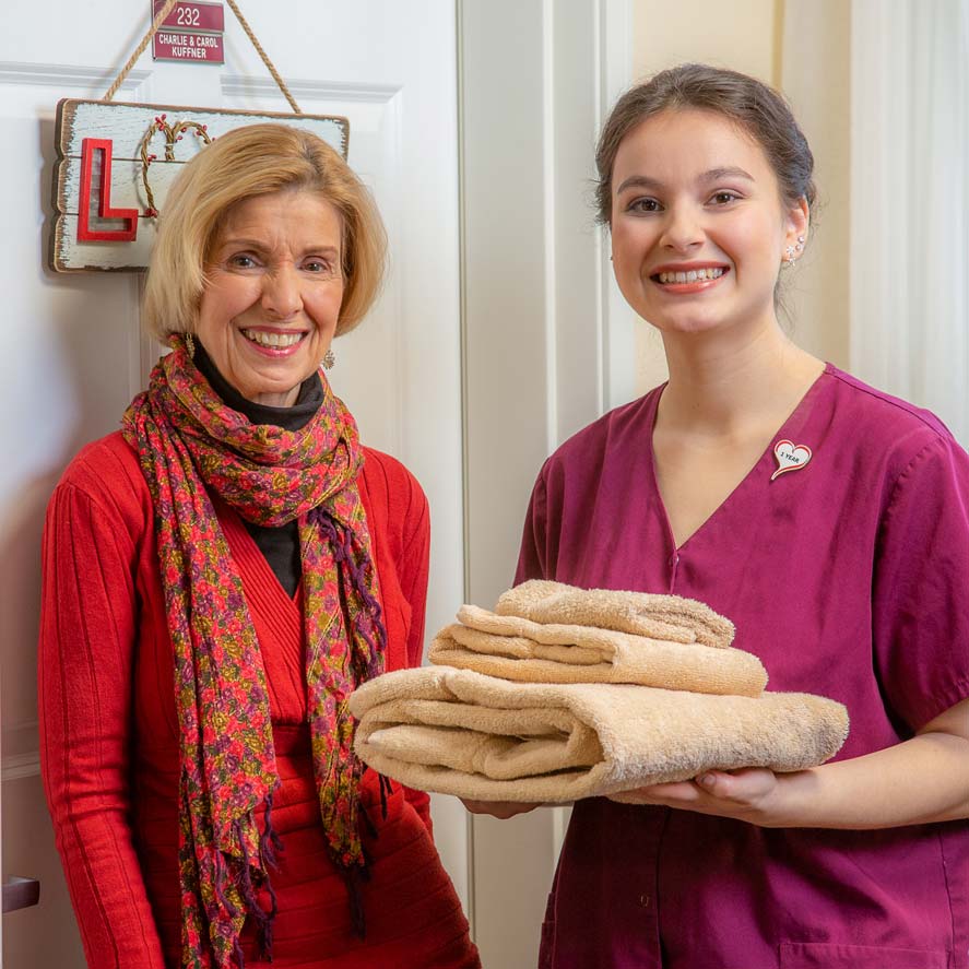 A team member delivering fresh linens to a resident at The Savoy